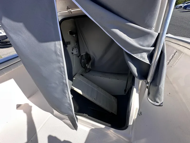 Slide: The Image of 2017 Yamaha Boats 190 FSH Sport interior storage area with curtain partially open. - 17