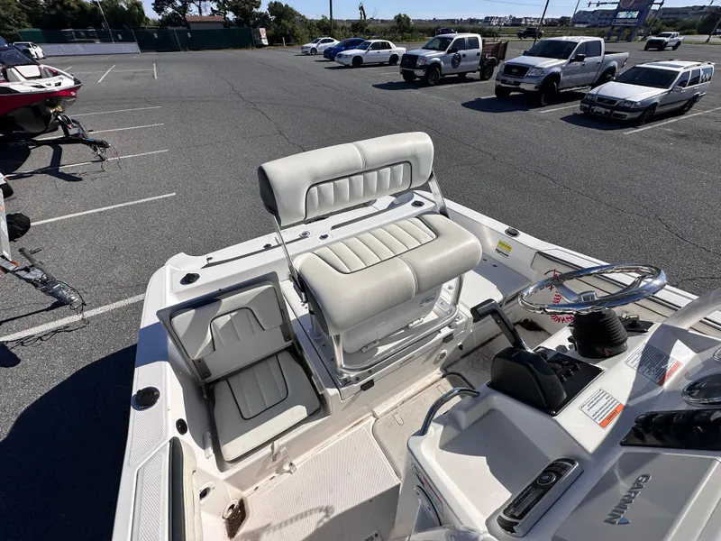 Slide: The Image of 2017 Yamaha Boats 190 FSH Sport interior with seating and steering wheel in a parking lot. - 9