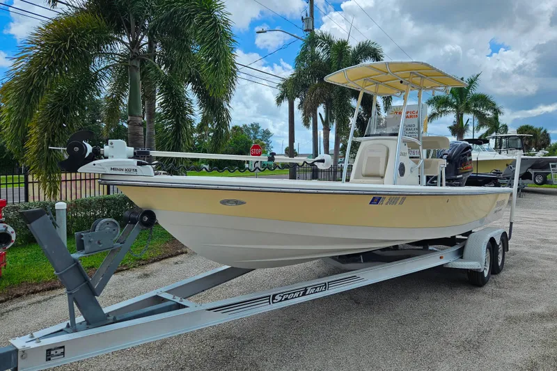 The Image of 2011 Pathfinder 2400 Tournament Edition boat on trailer, parked near palm trees. - 0