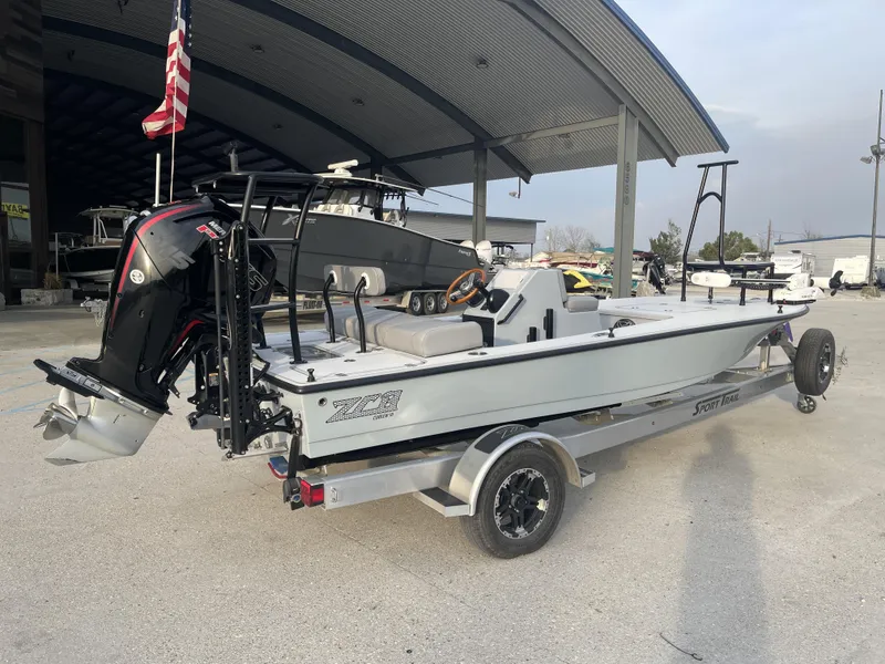 Slide: The Image of 2023 ZCB 18 Curlew boat on trailer, parked outdoors under a metal canopy. - 2