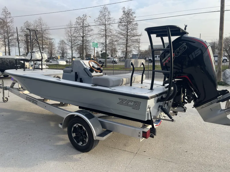Slide: The Image of 2023 ZCB 18 Curlew boat on trailer with Mercury 115 engine, parked outdoors. - 5
