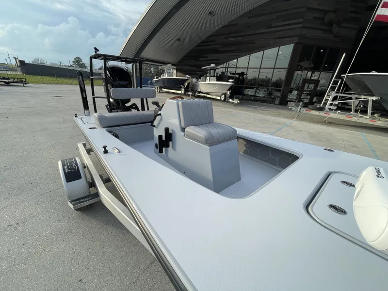 Slide: The Image of 2023 ZCB 18 Curlew boat displayed at a dealership, showcasing sleek design and seating. - 8
