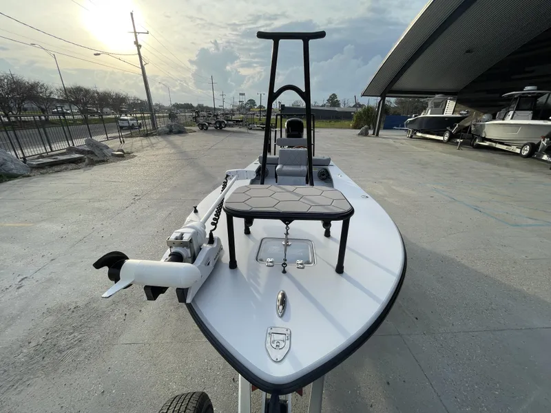 Slide: The Image of 2023 ZCB 18 Curlew boat on display at a dealership under a cloudy sky. - 9