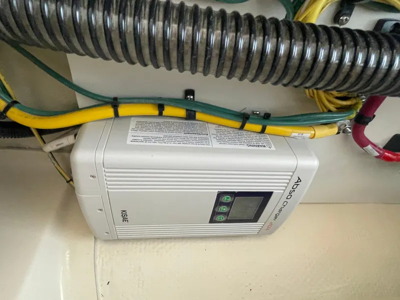 Slide: The Image of Battery charger in 2023 Ranger Tugs R-25 boat, with connected cables and wiring. - 14