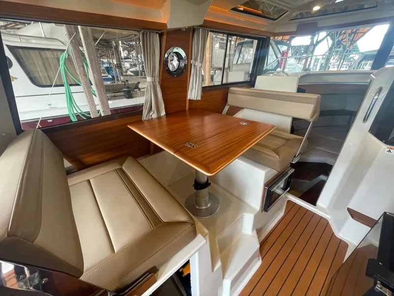 Slide: The Image of Interior of 2023 Ranger Tugs R-25 with seating and wooden table. - 18