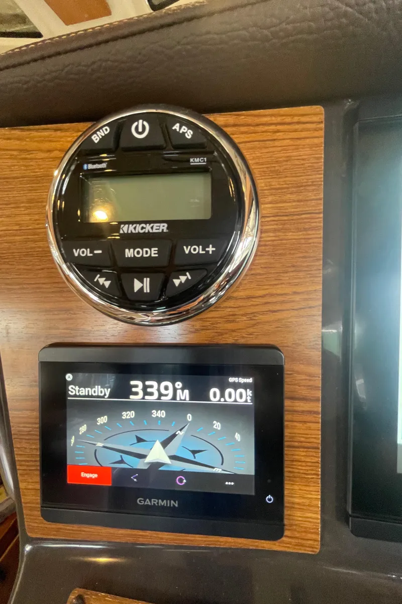 Slide: The Image of 2023 Ranger Tugs R-25 dashboard with Kicker audio controls and Garmin navigation display. - 31