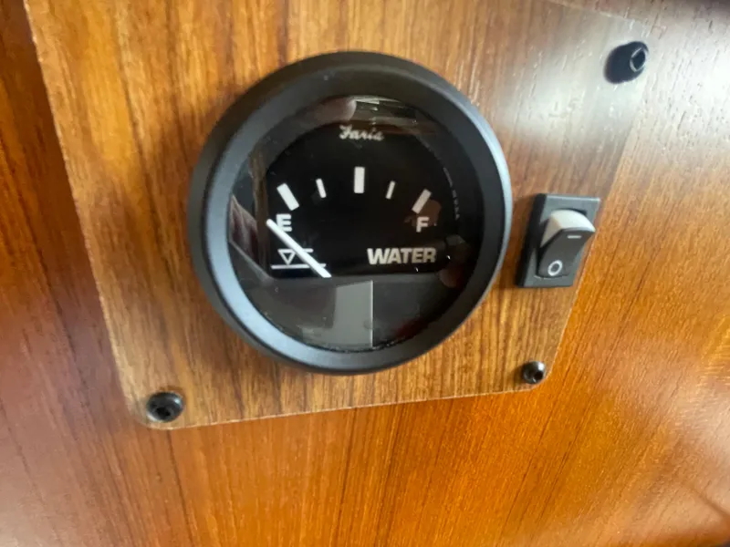 Slide: The Image of Water gauge on 2023 Ranger Tugs R-25 boat dashboard, showing empty to full levels. - 36