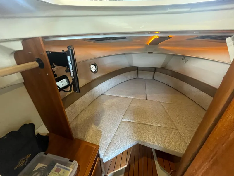 Slide: The Image of 2023 Ranger Tugs R-25 cabin interior with cushioned seating and wooden accents. - 37