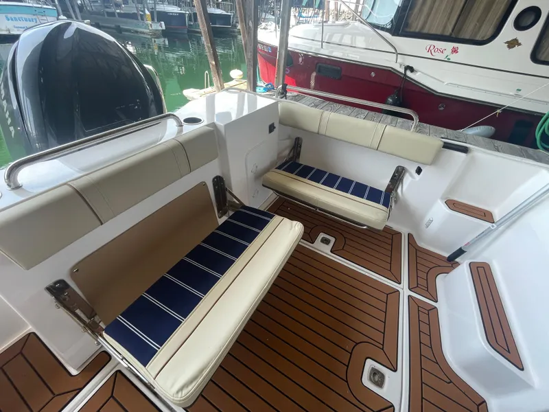 Slide: The Image of 2023 Ranger Tugs R-25 boat interior with cushioned seating and teak flooring. - 4