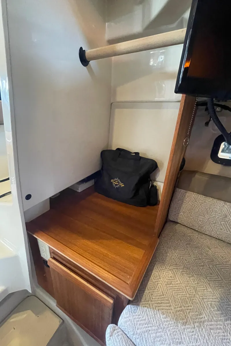 Slide: The Image of 2023 Ranger Tugs R-25 interior with wooden shelf, storage, and seating area. - 40