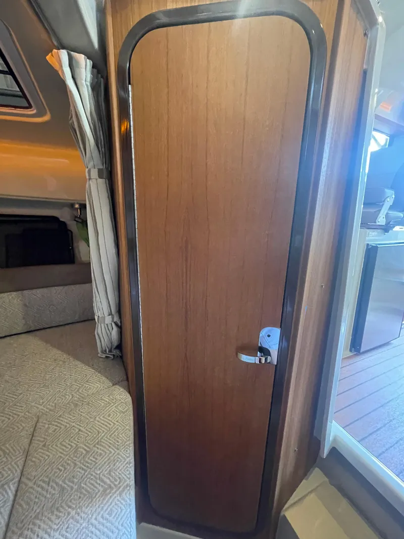 Slide: The Image of 2023 Ranger Tugs R-25 interior cabin door with wood finish and modern design. - 44