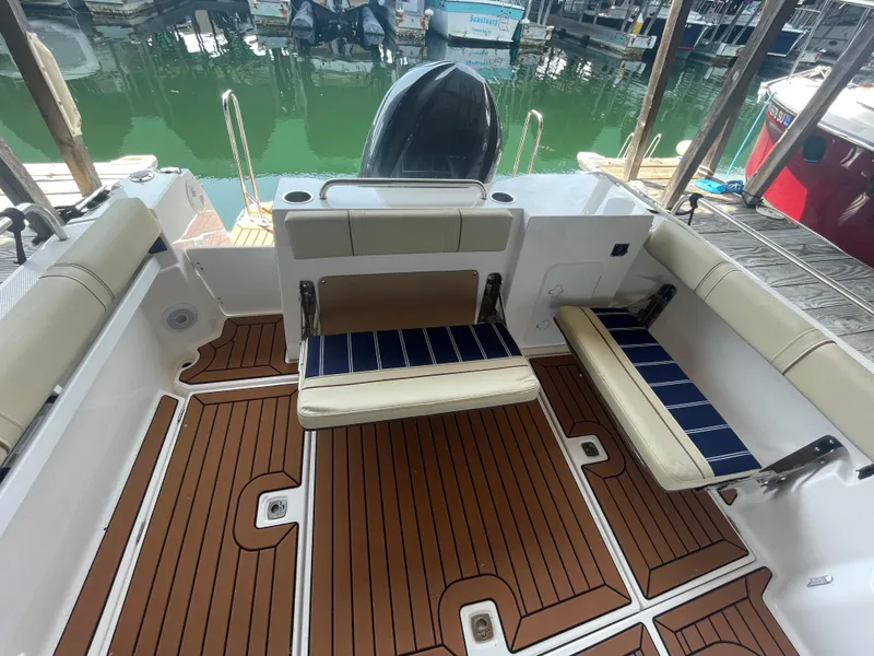 Slide: The Image of 2023 Ranger Tugs R-25 boat interior with teak flooring and cushioned seating. - 5