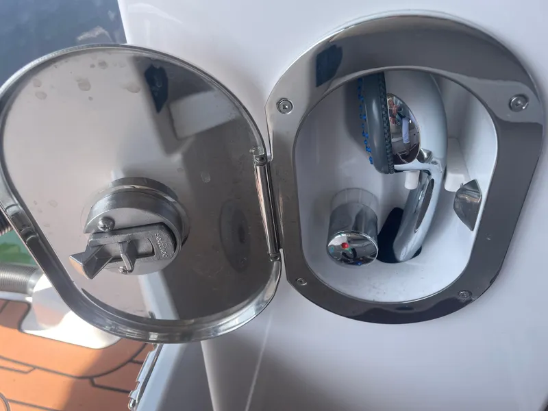 Slide: The Image of 2023 Ranger Tugs R-25 boat shower compartment with chrome fixtures and open hatch. - 8