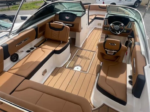 Slide: The Image of 2023 Chaparral 247 SSX boat interior with tan seating and modern dashboard. - 4