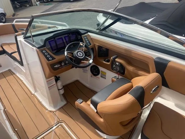 Slide: The Image of 2023 Chaparral 247 SSX boat interior with modern dashboard and tan seating. - 7