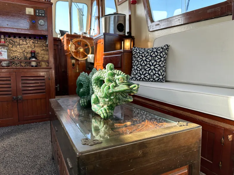 Slide: The Image of 1973 CHB Trawler interior with jade dragon sculpture, wooden accents, and nautical decor. - 17