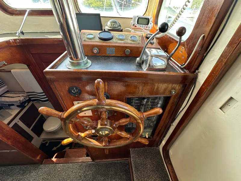 Slide: The Image of 1973 CHB Trawler helm with wooden wheel and vintage controls. - 19