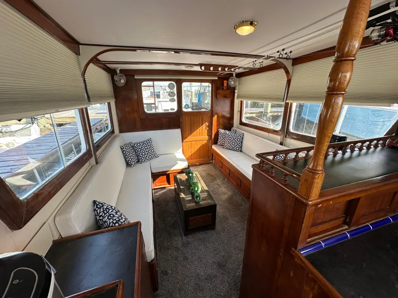 Slide: The Image of 1973 CHB Trawler interior with cozy seating, wooden accents, and nautical decor. - 22