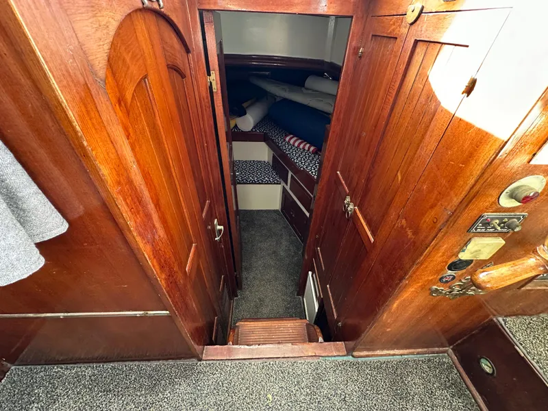 Slide: The Image of 1973 CHB Trawler interior with wooden cabinetry and cozy sleeping quarters. - 26