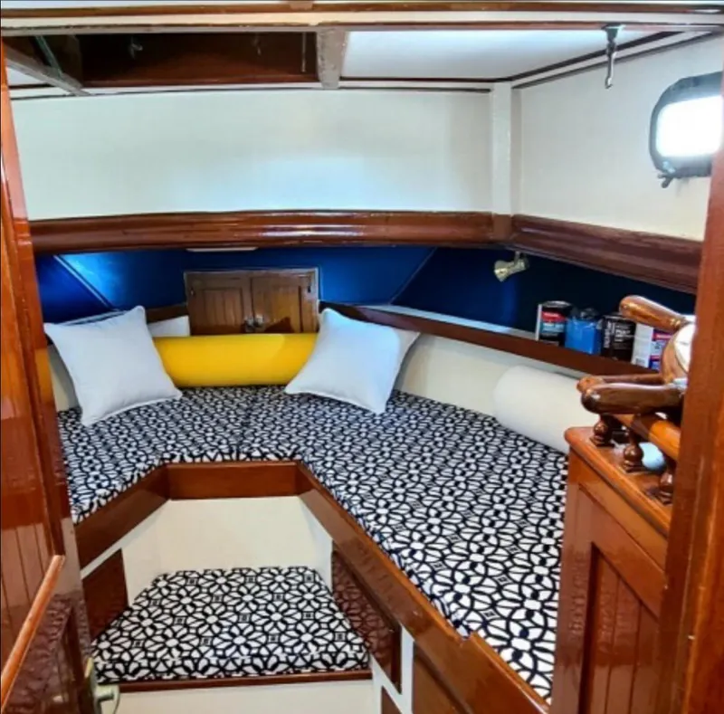 Slide: The Image of 1973 CHB Trawler cabin interior with patterned bedding and wooden accents. - 27