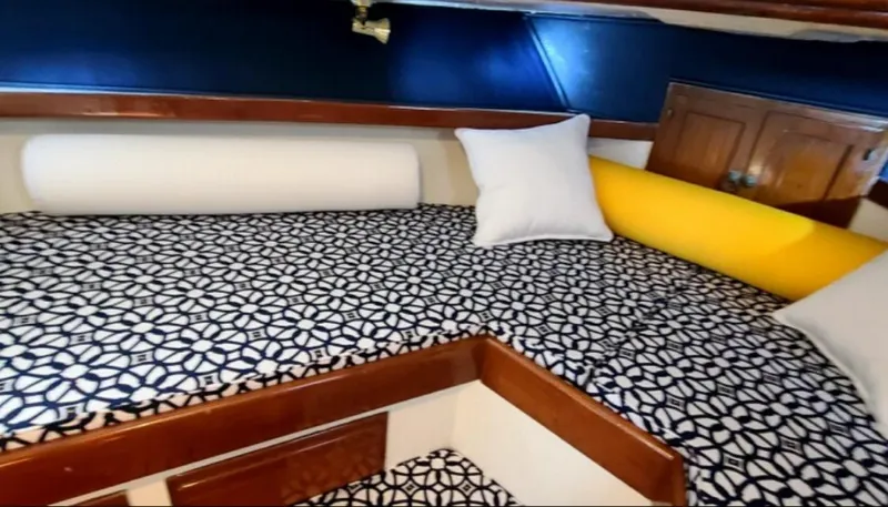 Slide: The Image of 1973 CHB Trawler cabin with patterned bedding and colorful pillows. - 28