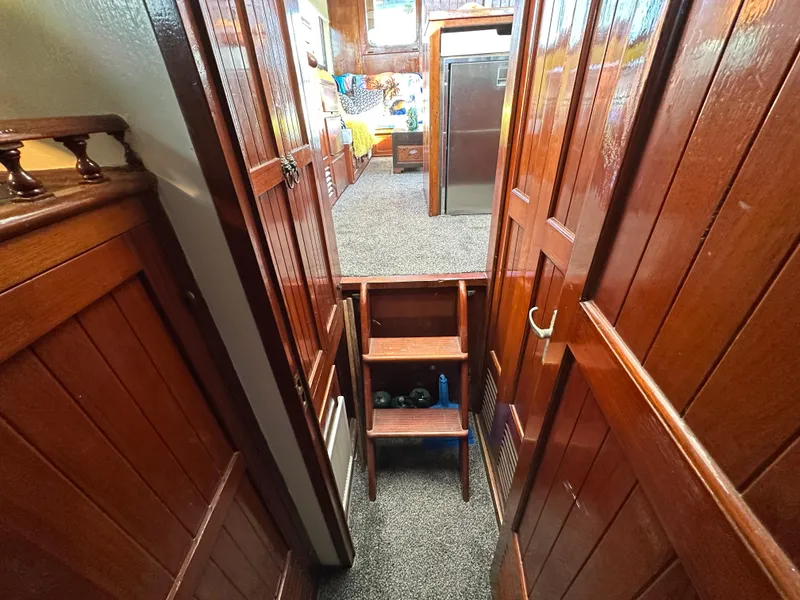 Slide: The Image of 1973 CHB Trawler interior with wooden paneling and carpeted flooring. - 29