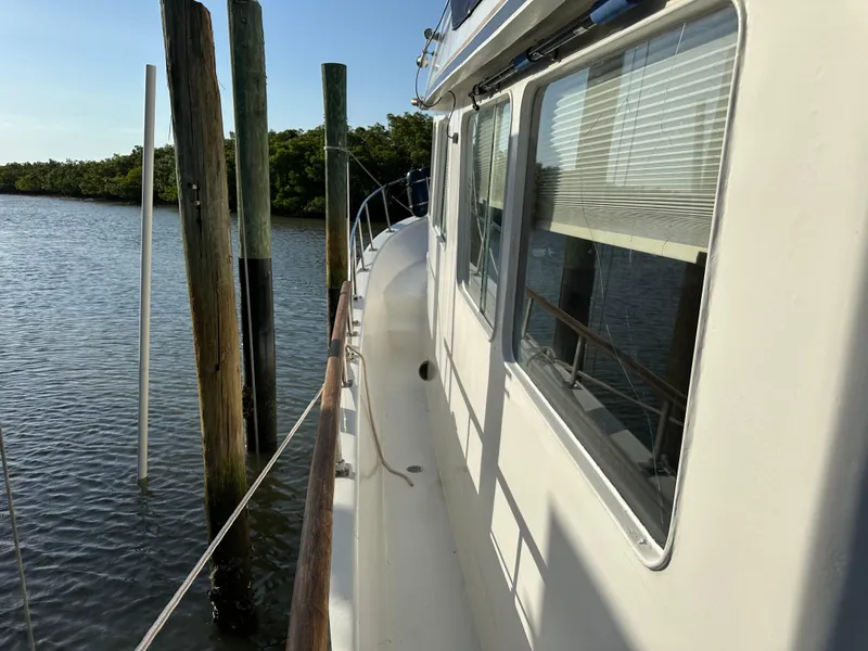 Slide: The Image of 1973 CHB Trawler docked by wooden posts on a sunny day. - 4