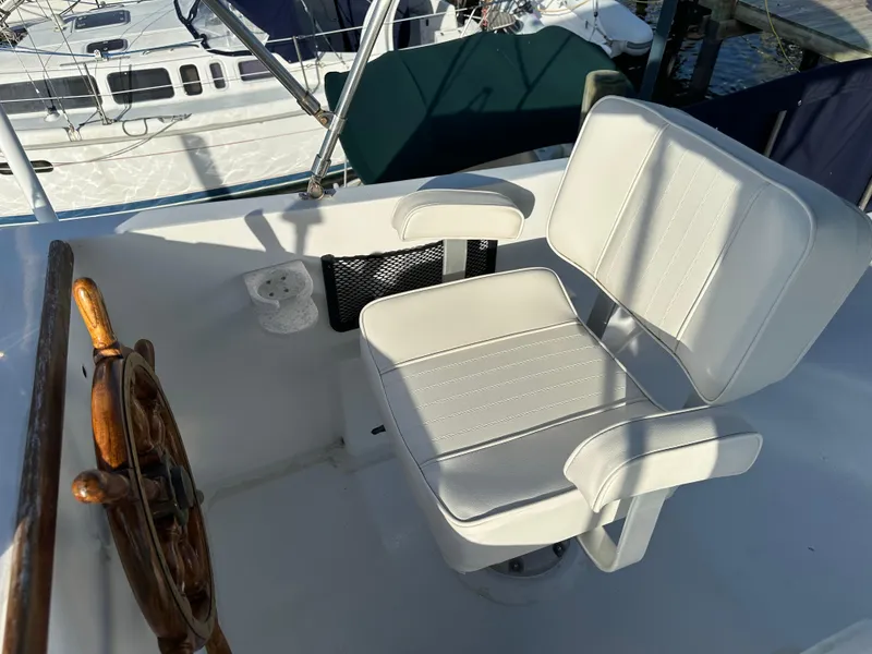 Slide: The Image of 1973 CHB Trawler helm with white captain's chair and wooden steering wheel. - 9