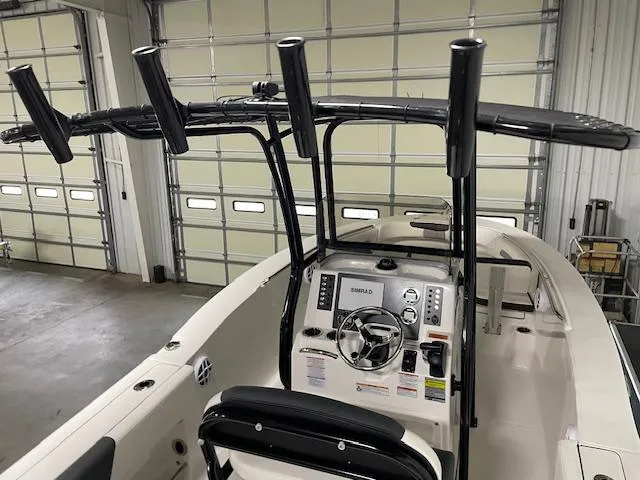 Slide: The Image of 2025 Robalo R202 Explorer boat interior with steering console and rod holders. - 2