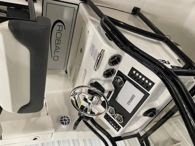 Slide: The Image of 2025 Robalo R202 Explorer boat dashboard with steering wheel and control panel. - 8