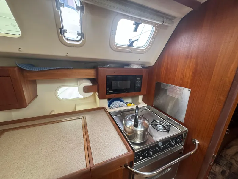 Slide: The Image of Compact kitchen in 1998 Hunter 410 sailboat with stove, microwave, and wooden cabinetry. - 12