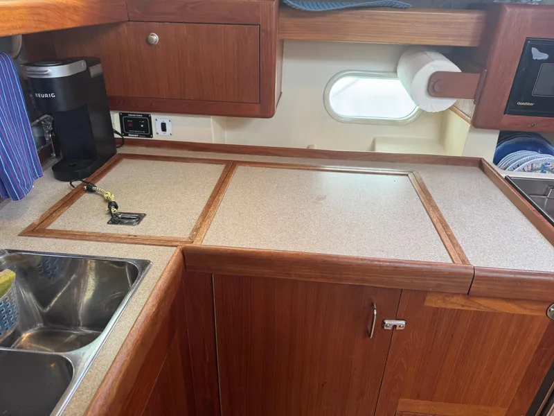 Slide: The Image of Wooden kitchen interior of a 1998 Hunter 410 sailboat with sink and countertop. - 14