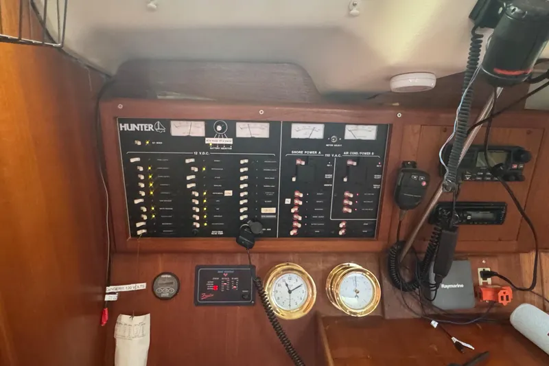 Slide: The Image of Electrical control panel inside a 1998 Hunter 410 sailboat cabin with gauges and communication devices. - 20