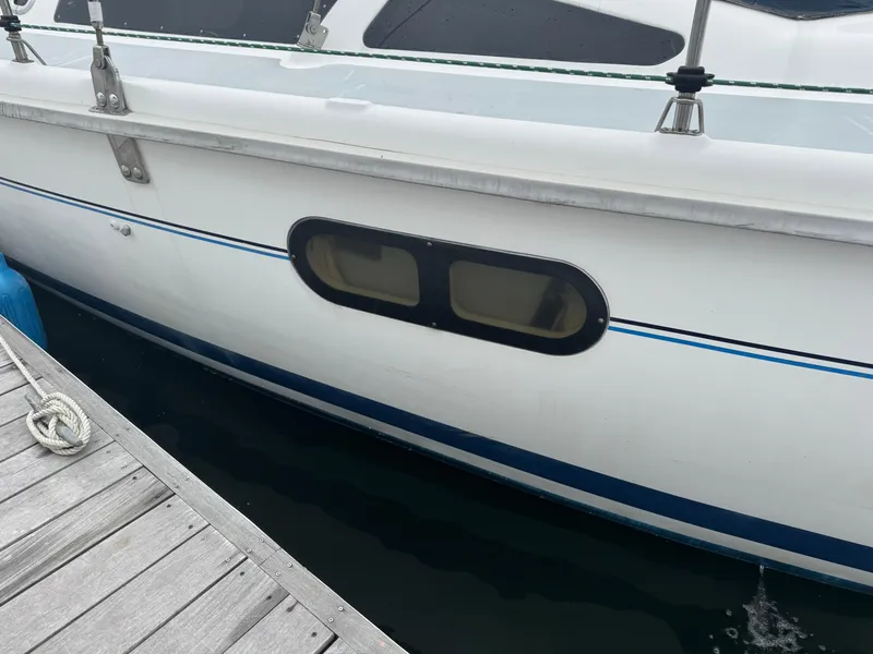 Slide: The Image of 1998 Hunter 410 sailboat docked, showing side window and railing details. - 29
