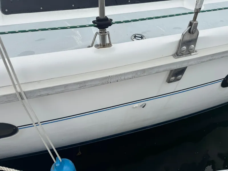 Slide: The Image of Side view of a 1998 Hunter 410 sailboat docked, showing deck fittings and hull details. - 32