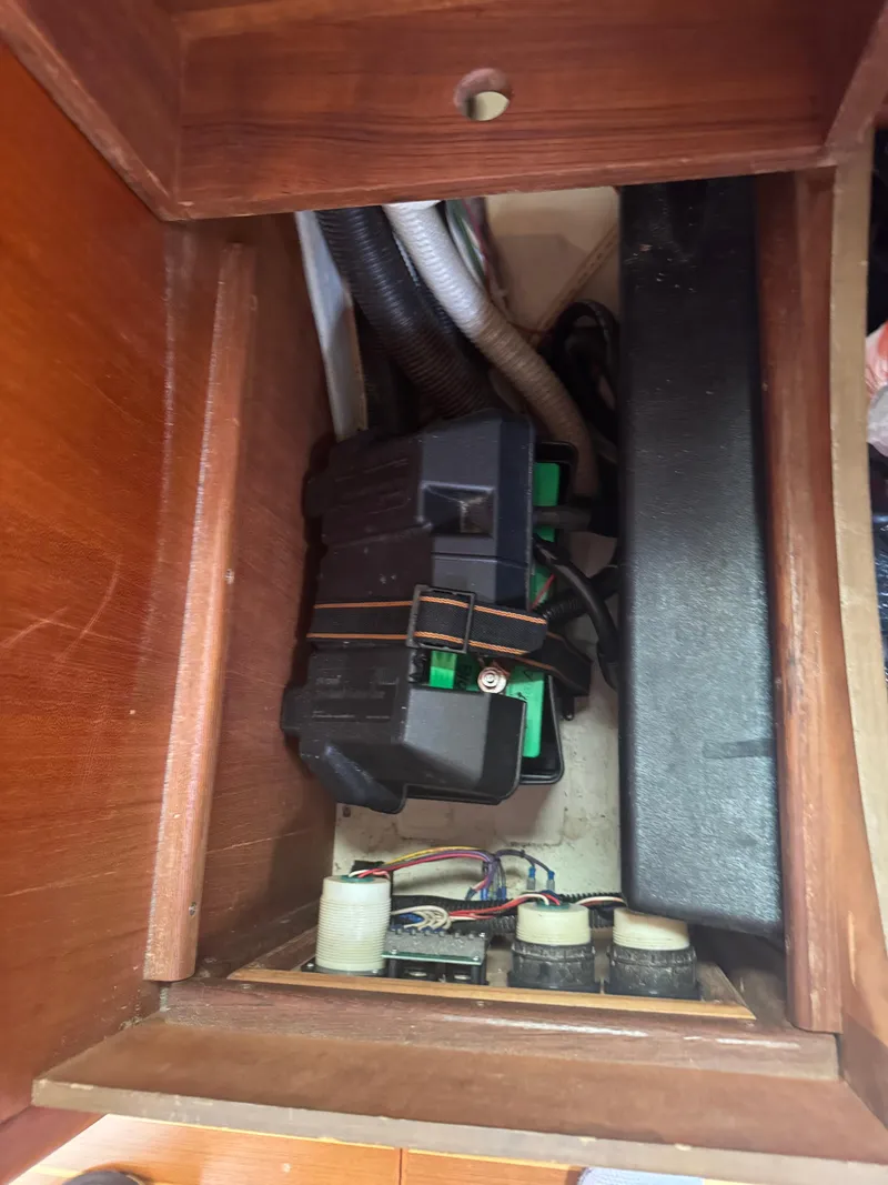 Slide: The Image of Electrical components inside a wooden compartment of a 1998 Hunter 410 model. - 4