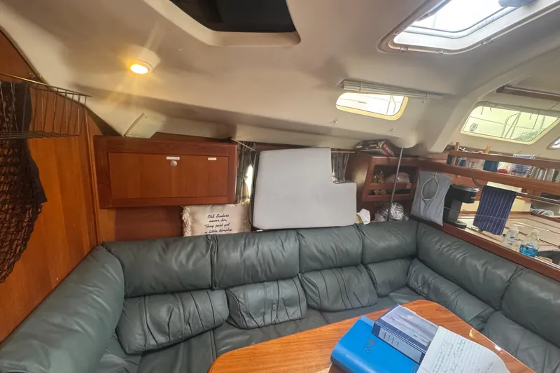 Slide: The Image of Cozy interior of 1998 Hunter 410 sailboat with cushioned seating and wooden table. - 8