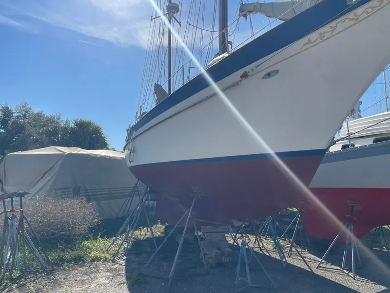 The Image of 1976 Cheoy Lee Clipper 42 sailboat on stands under a clear blue sky. - 0