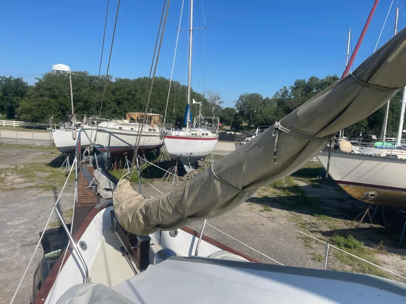 Slide: The Image of 1976 Cheoy Lee Clipper 42 sailboat docked, surrounded by other boats, under clear blue sky. - 10