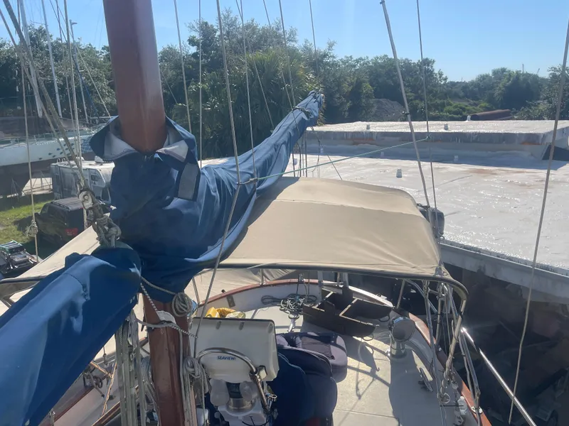 Slide: The Image of 1976 Cheoy Lee Clipper 42 sailboat with covered deck, docked under clear skies. - 13