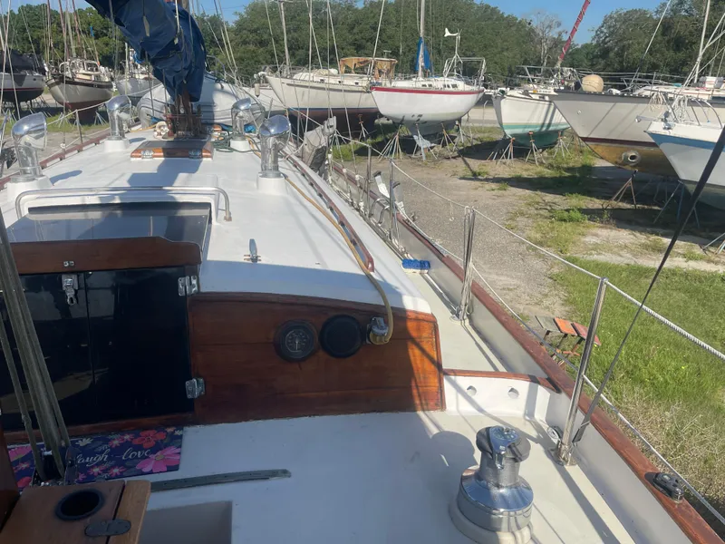 Slide: The Image of 1976 Cheoy Lee Clipper 42 sailboat on land, surrounded by other boats. - 18
