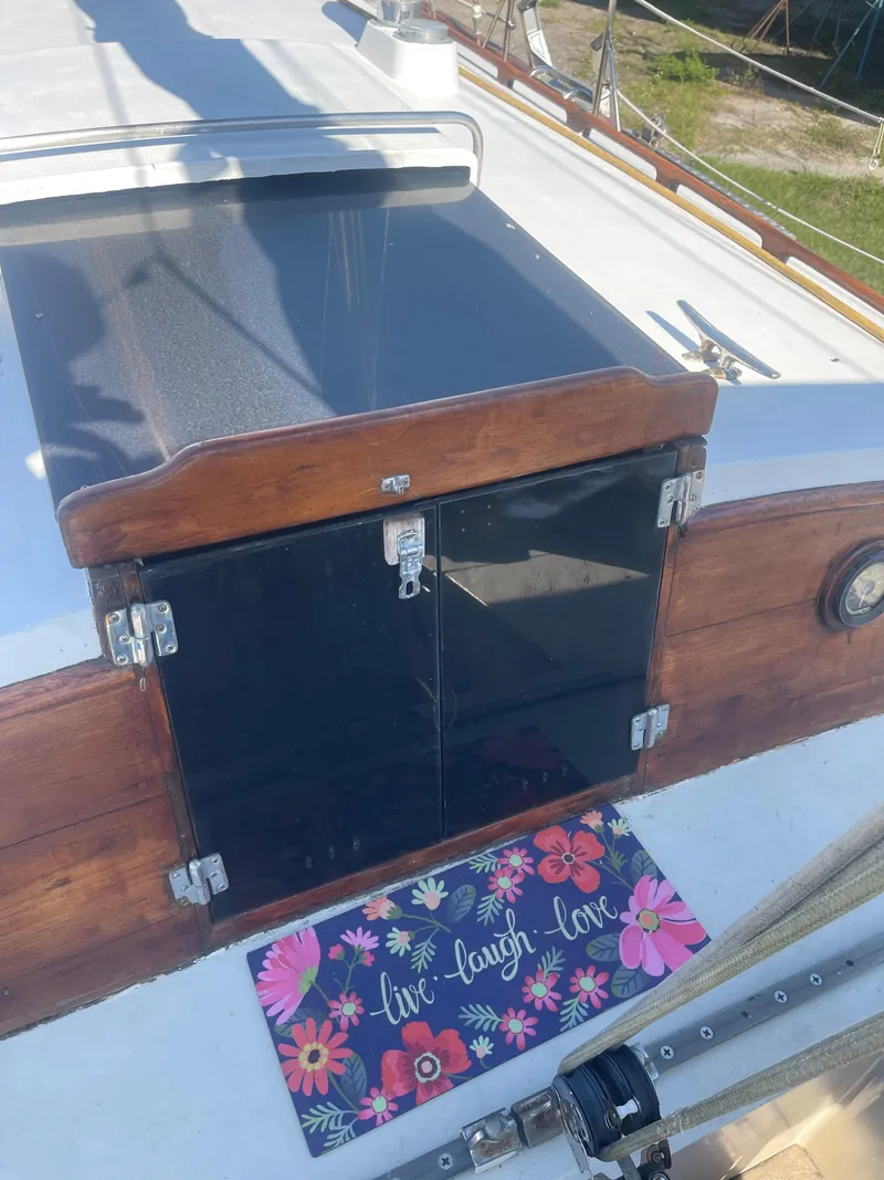 Slide: The Image of 1976 Cheoy Lee Clipper 42 yacht deck with floral mat and wooden hatch. - 19