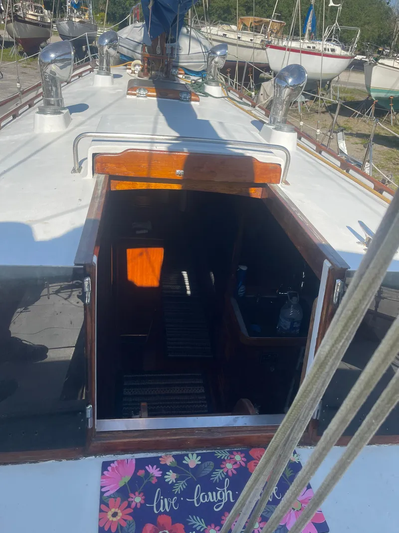 Slide: The Image of 1976 Cheoy Lee Clipper 42 sailboat deck with open cabin entrance and floral mat. - 20