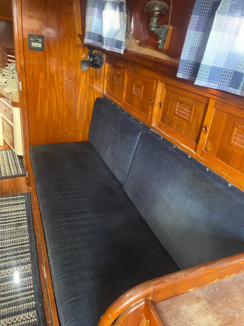 Slide: The Image of 1976 Cheoy Lee Clipper 42 interior with wooden paneling and cushioned seating. - 25