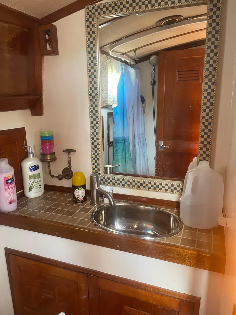 Slide: The Image of 1976 Cheoy Lee Clipper 42 bathroom with sink, mirror, and toiletries. - 31