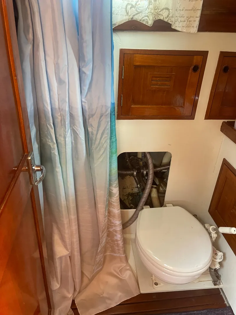 Slide: The Image of 1976 Cheoy Lee Clipper 42 yacht bathroom with wooden cabinets and a toilet. - 34