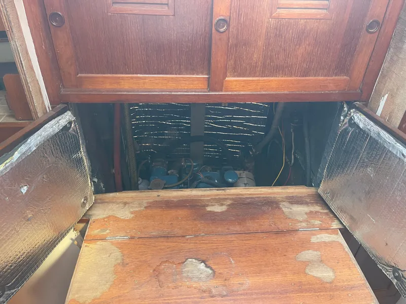 Slide: The Image of Engine compartment of a 1976 Cheoy Lee Clipper 42 sailboat with wooden access panels. - 35