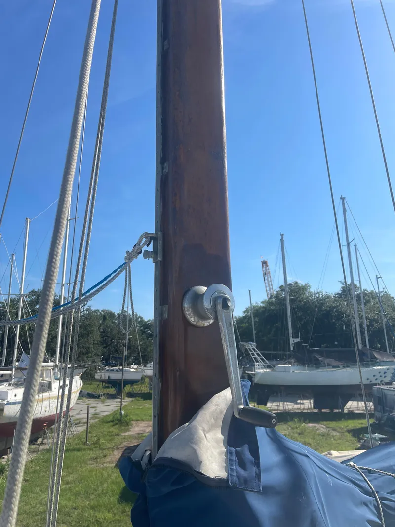 Slide: The Image of 1976 Cheoy Lee Clipper 42 sailboat mast with winch handle, docked under clear blue sky. - 9