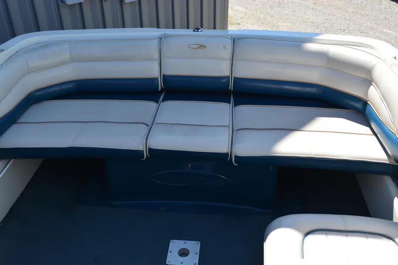 Slide: The Image of 1997 Maxum 2300 SR boat interior with white and blue cushioned seating. - 10
