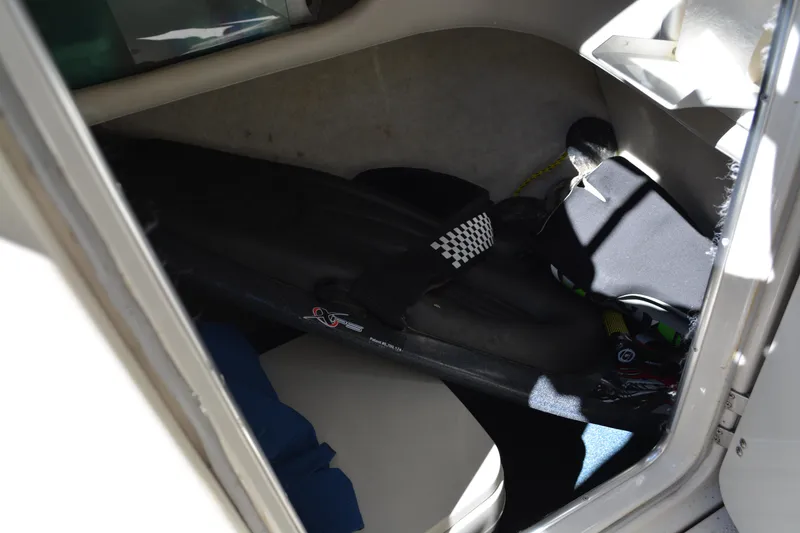 Slide: The Image of Storage compartment in a 1997 Maxum 2300 SR boat, containing various equipment. - 14